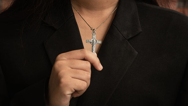 Woman wearing and showcasing her cross necklace | Glor-e