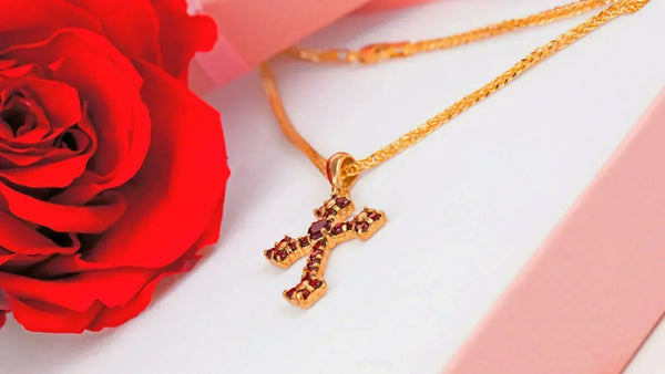 A Cross Necklace From Glor-e in A Gift Box Next To A Red Rose