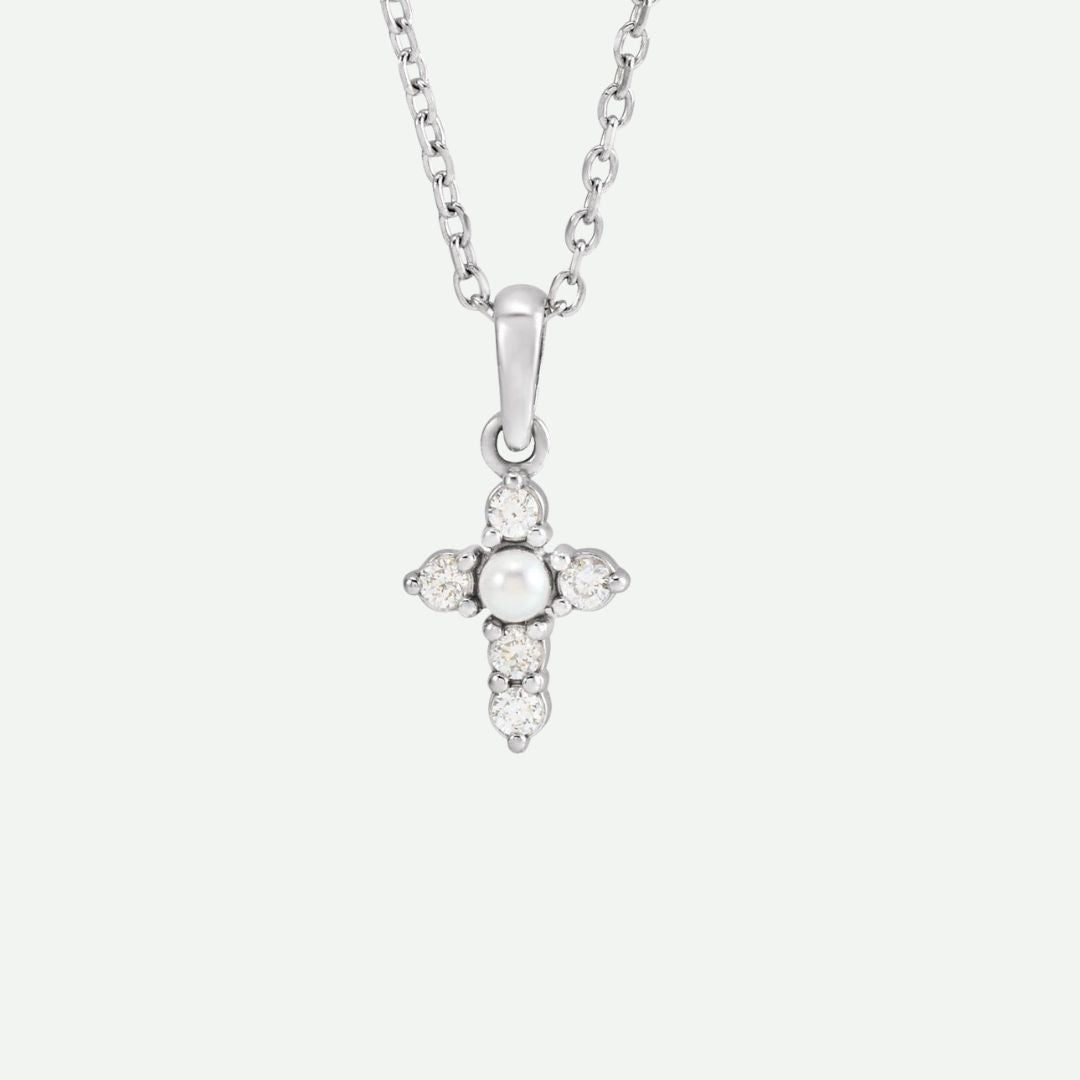 Front view of the GRACED necklace in sterling silver, featuring a seed pearl and diamonds on the cross as a symbol of grace and faith.