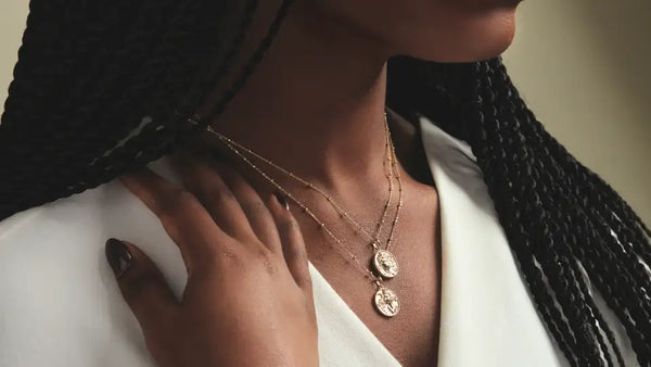 Female model wearing layered Christian necklaces from Glor-e