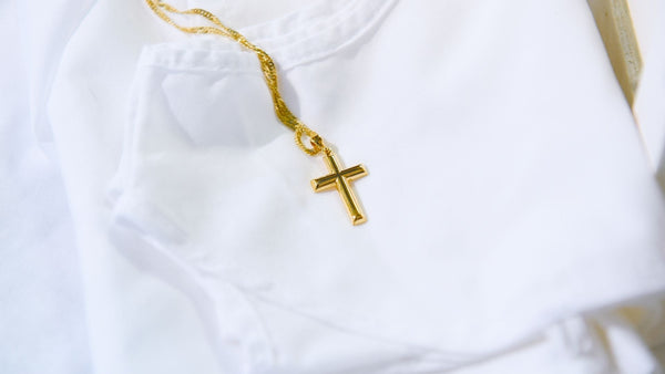 Yellow Gold Cross Necklace on a White Folded T-Shirt | Modern Christian Jewelry | Glor-e