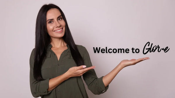 Smiling Brunette Pointing to Welcome to Sign | Glor-e - Inspiring Christian Jewelry