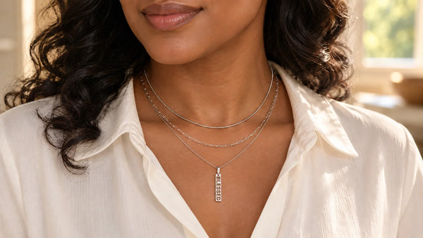 Woman wearing Glor-e BLESSED necklace with BOX and PAPERCLIP sterling silver chains and an ivory blouse.