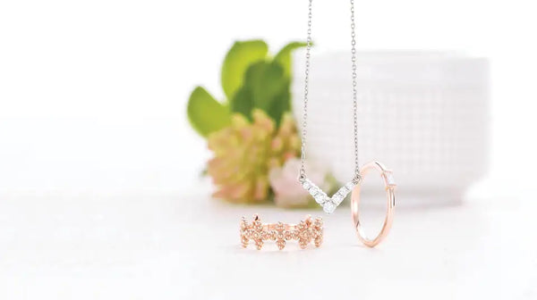 Christian Jewelry On Display On White Background With Blurry Flower