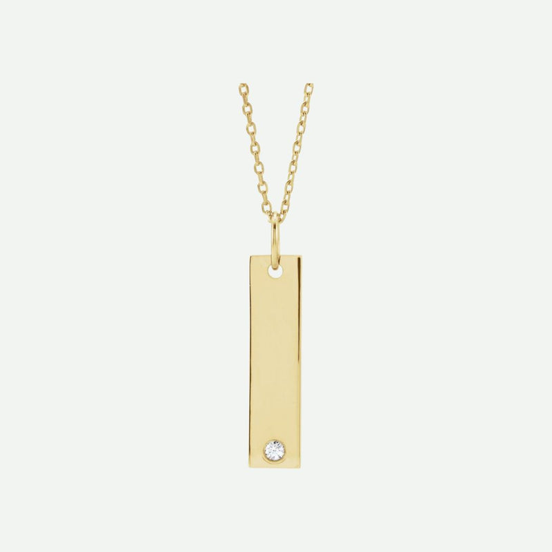 Gold necklace with a rectangular pendant featuring a diamond on a white background