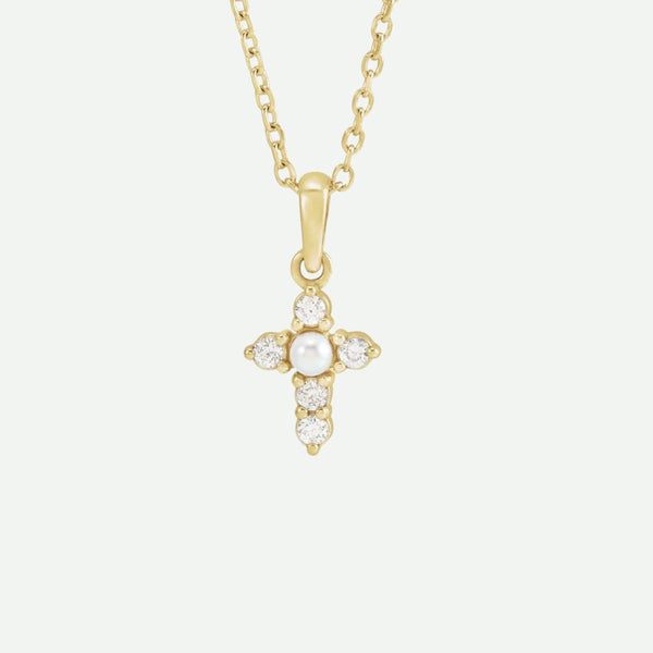 Front view of the GRACED necklace in yellow gold, featuring a cross adorned with a seed pearl and diamonds, symbolizing grace and enduring faith.