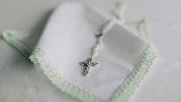 Silver cross necklace on a light green lace fabric - modern Christian jewelry from Glor-e