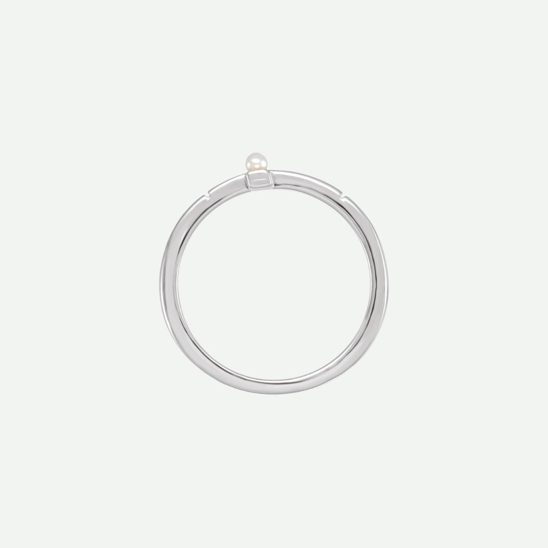 Top view of the PRECIOUS sideways cross ring in sterling silver, accented by a white Akoya pearl as a symbol of purity and faith.