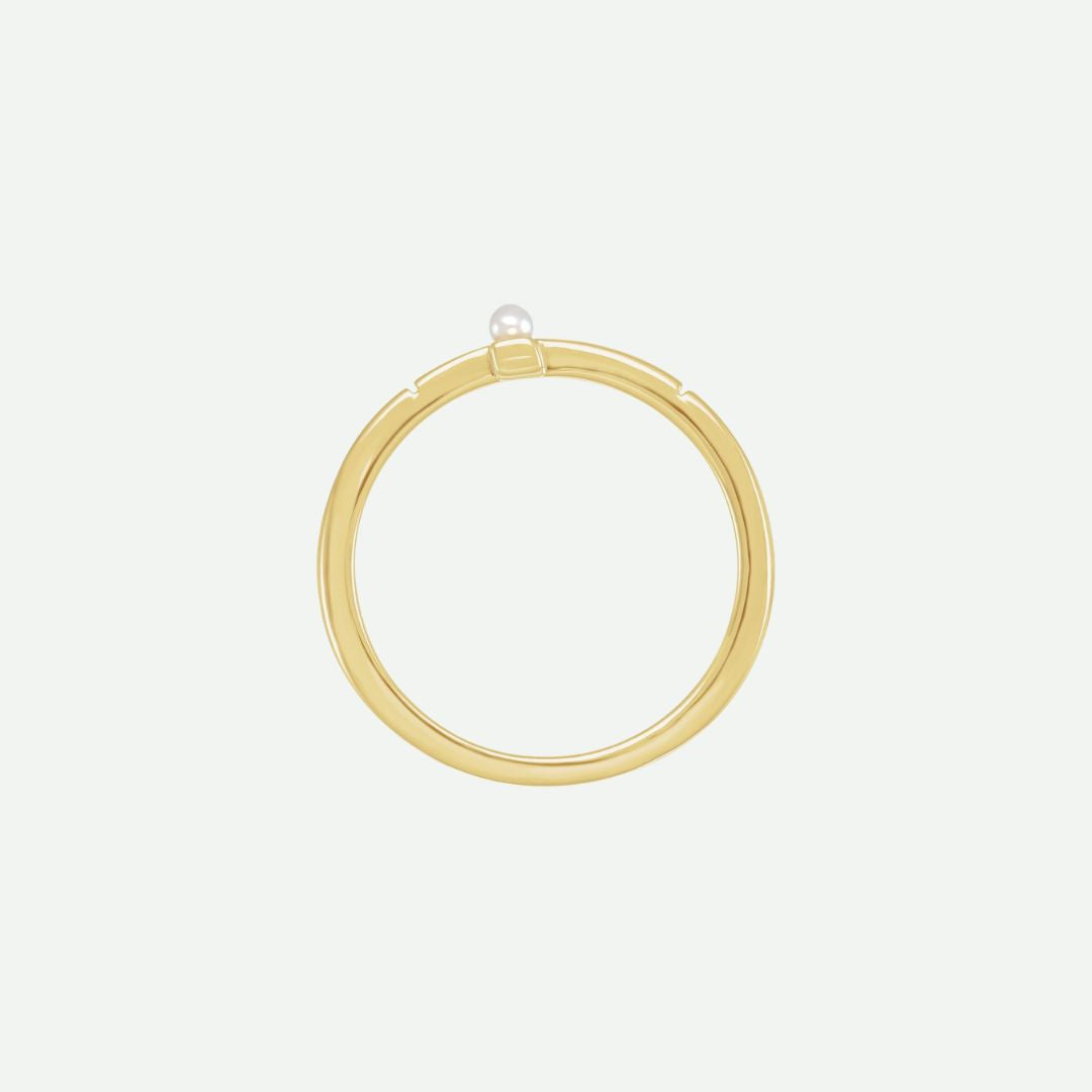 Top view of the PRECIOUS sideways cross ring in yellow gold with a centered white Akoya pearl, symbolizing purity and treasured faith.